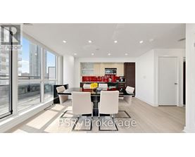A modern dining room with a glass table and chairs.