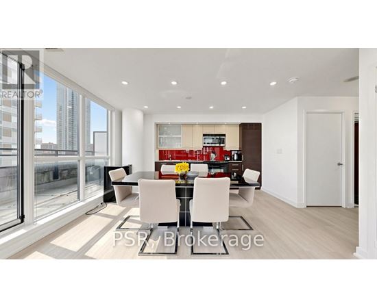 A modern dining room with a glass table and chairs.
