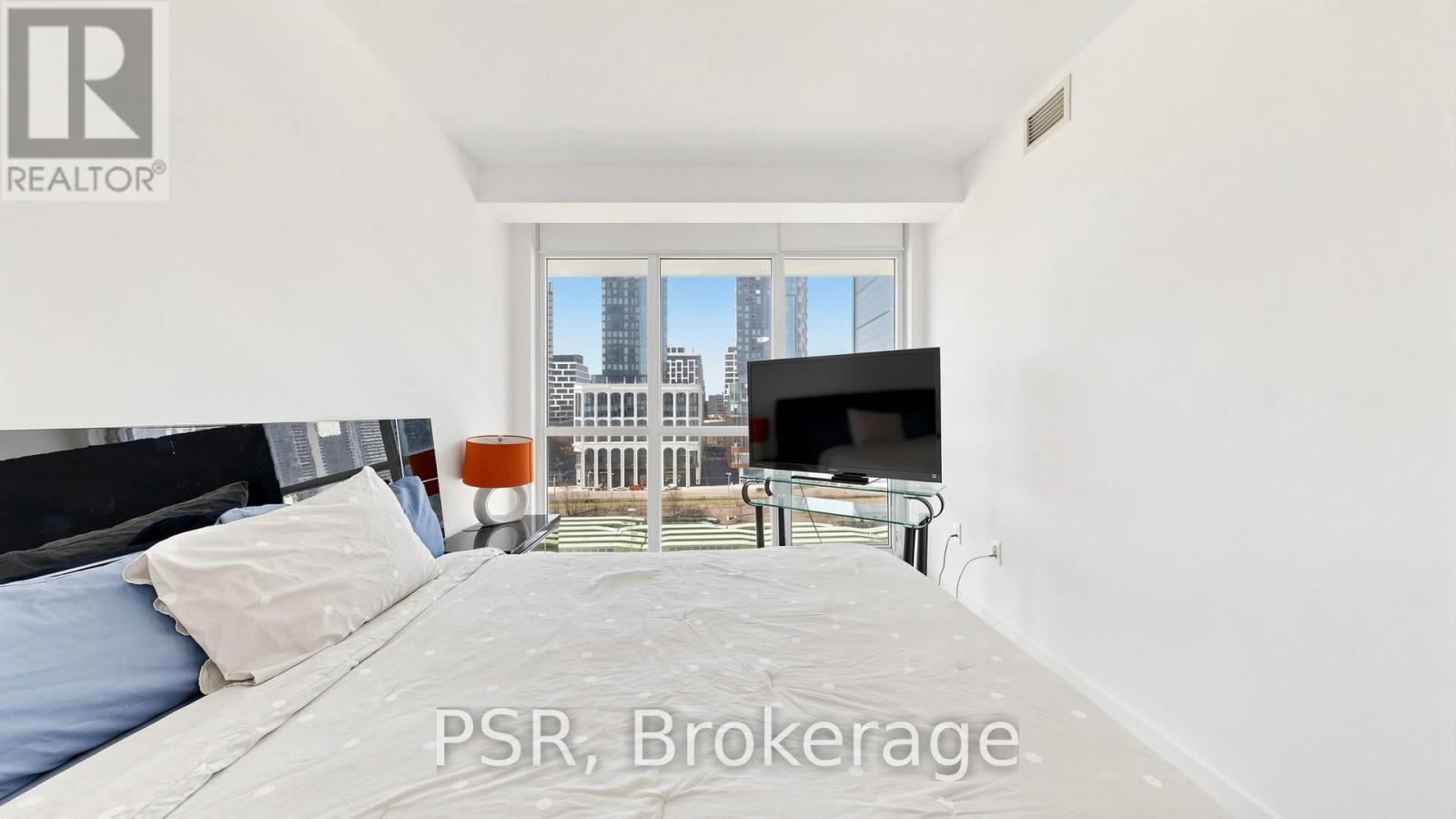 A bedroom with a large bed and a view of the city.
