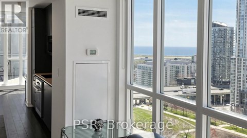 A view from a window of a cityscape with buildings and a clear sky.