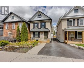 A street view of a residential area with houses and a real estate company logo.