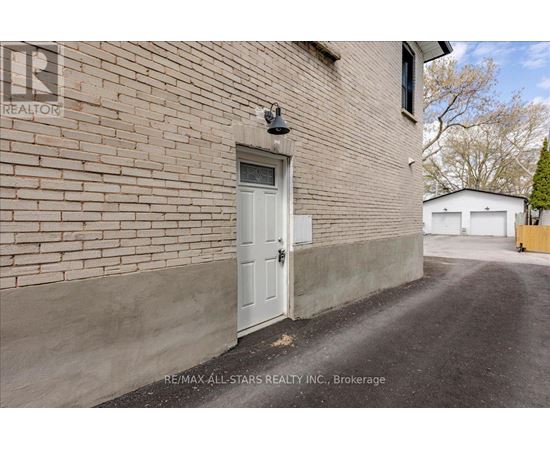 A white door is on the side of a brick building.