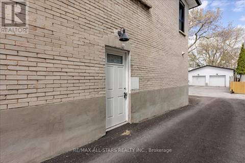 A white door is on the side of a brick building.