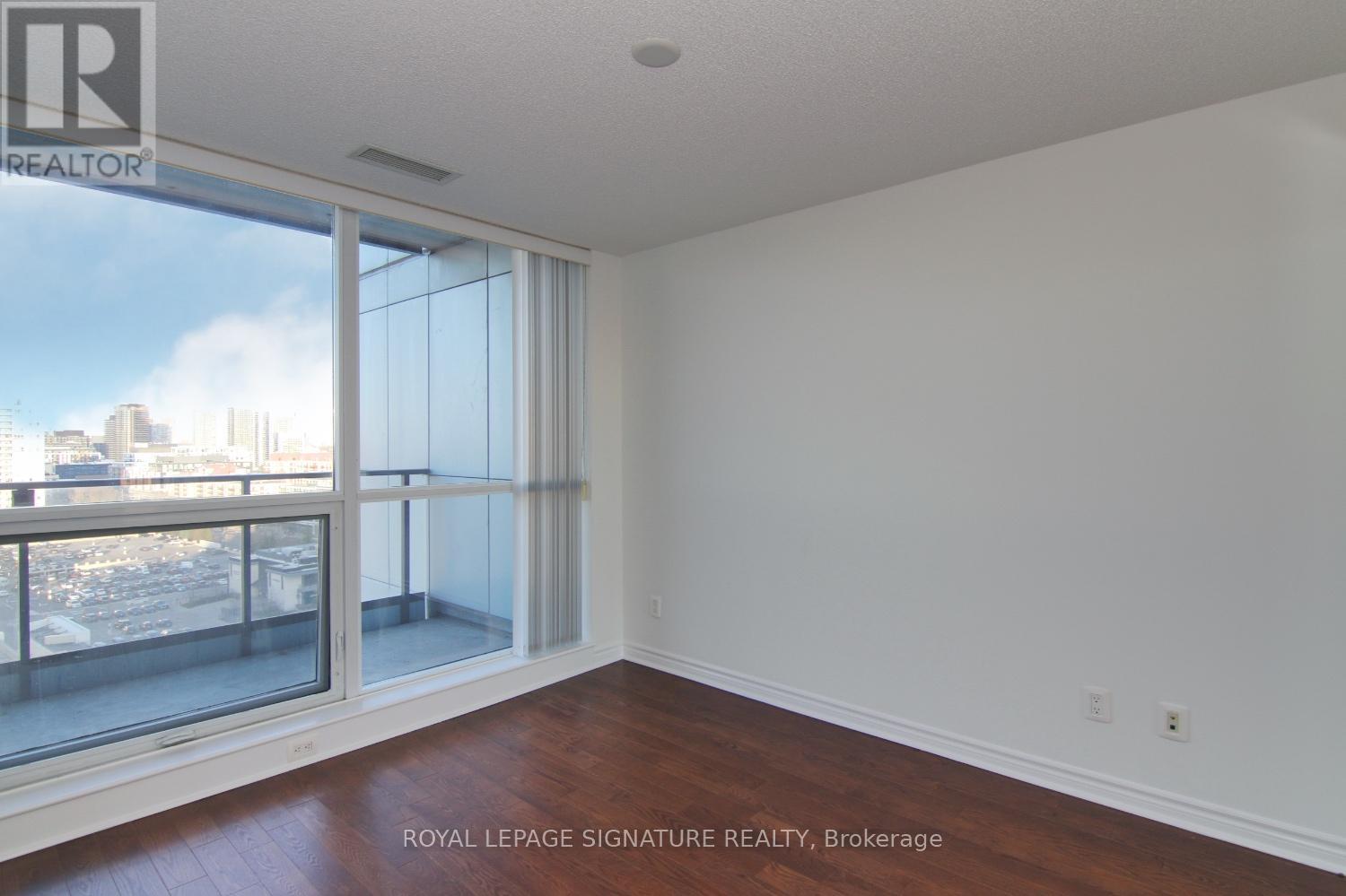A room with a large window and wooden floors.