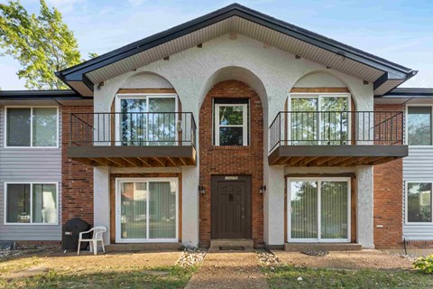 A two-story house with a balcony on the second floor.