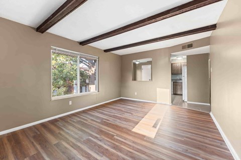 A room with wooden flooring and a large window.