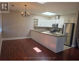 A well-lit kitchen with a dining area and a chandelier.