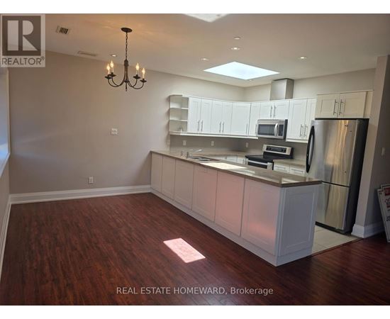 A well-lit kitchen with a dining area and a chandelier.