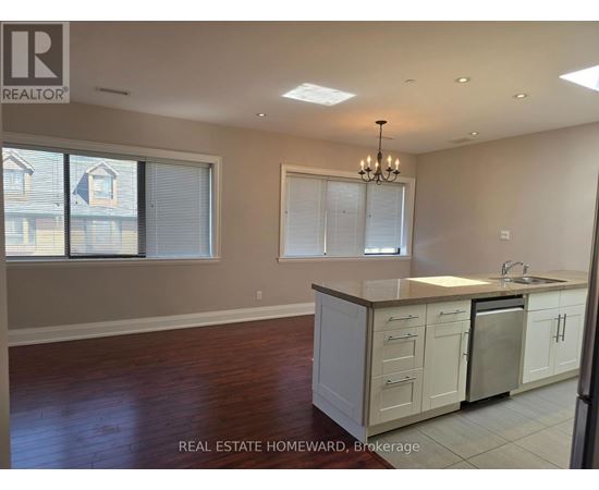 A kitchen with white cabinets and a wooden floor.