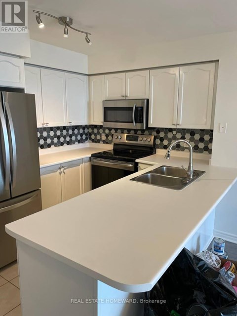 A kitchen with a sink and a refrigerator.