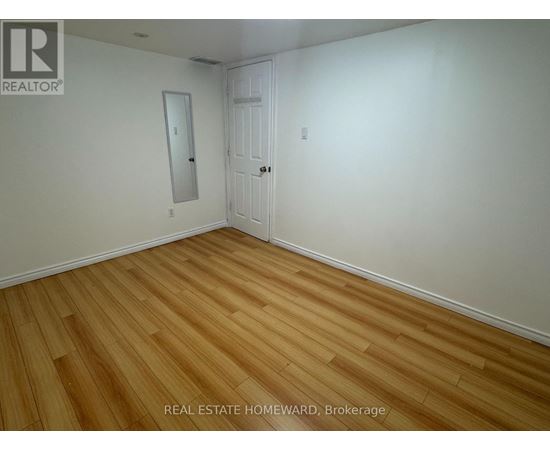A room with wooden flooring and a white door.