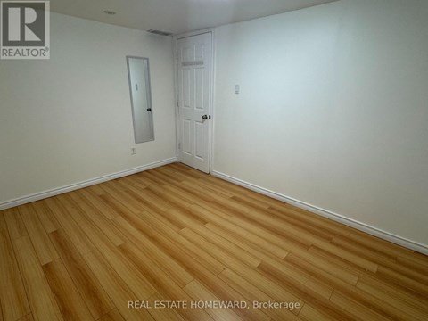 A room with wooden flooring and a white door.