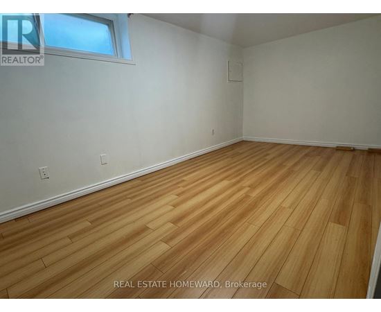 A room with wooden flooring and a window.