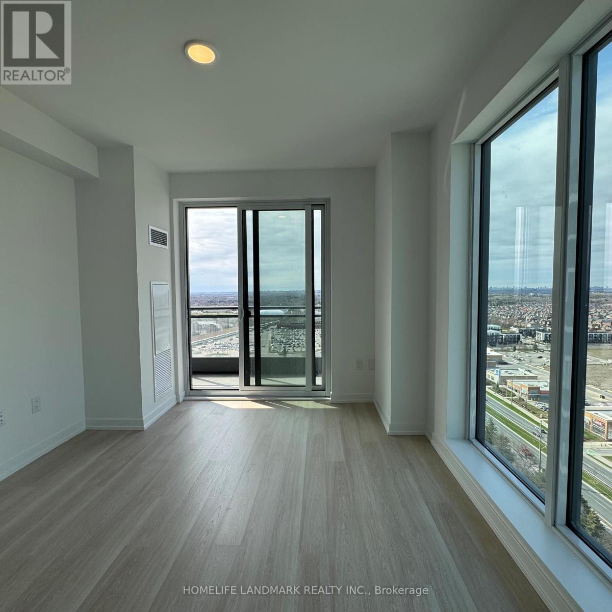 A spacious room with a view of the city through large windows.