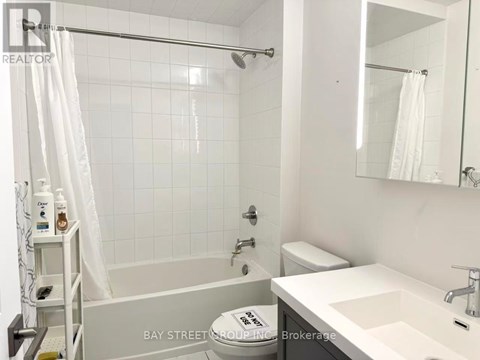 A white bathroom with a toilet, sink, and bathtub.