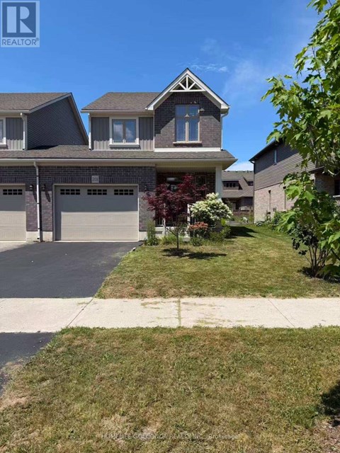 A house with a garage and a driveway in front of it.