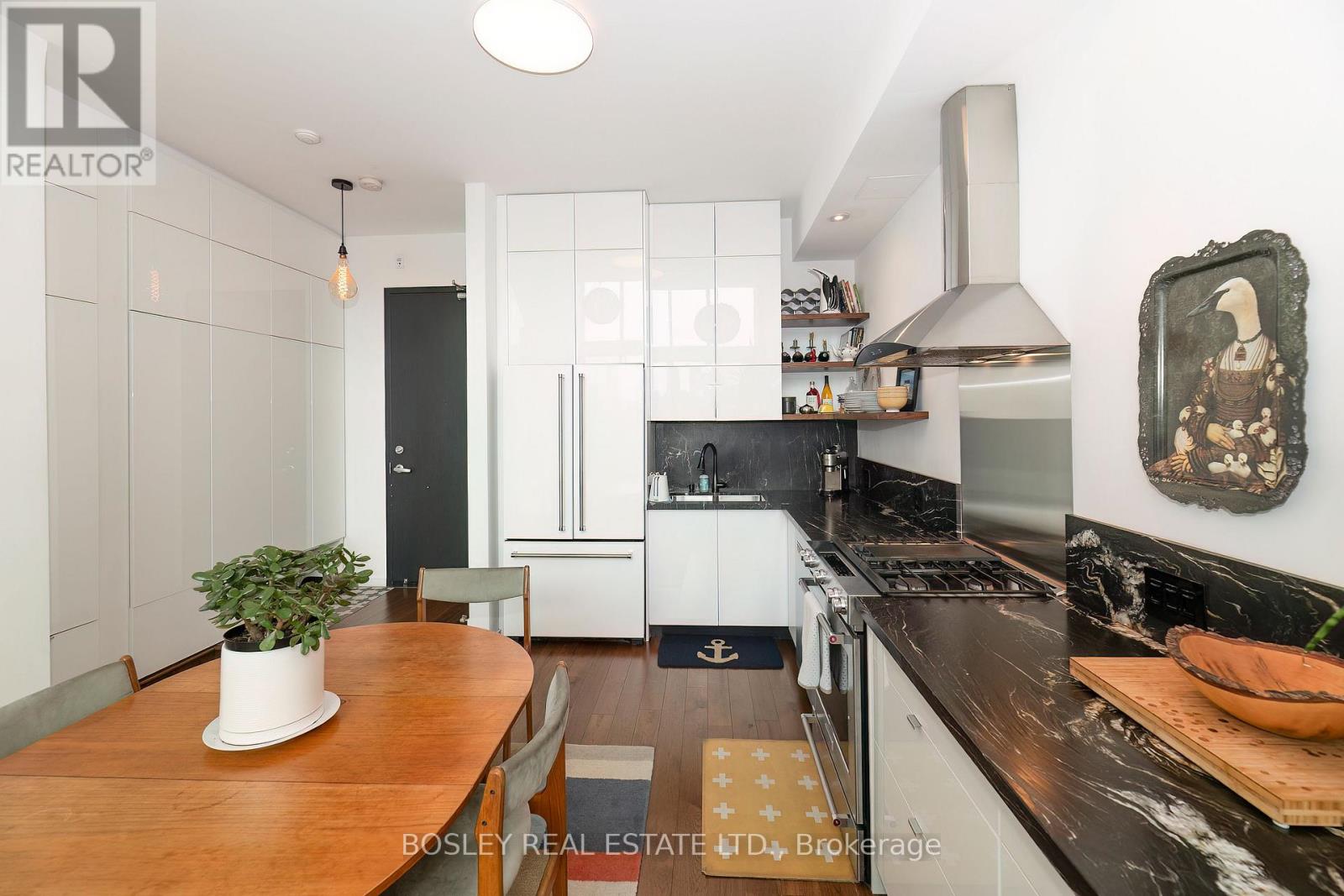 A modern kitchen with a wooden table and a plant on it.