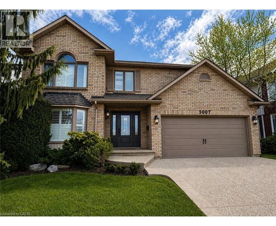 A house with a garage and a driveway in front.