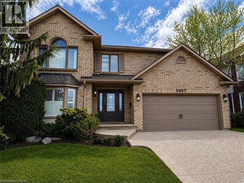 A house with a garage and a driveway in front.