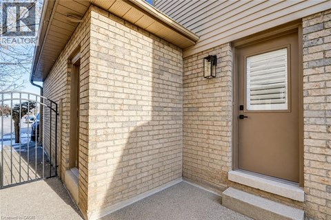 A brick house with a brown door and a black gate.