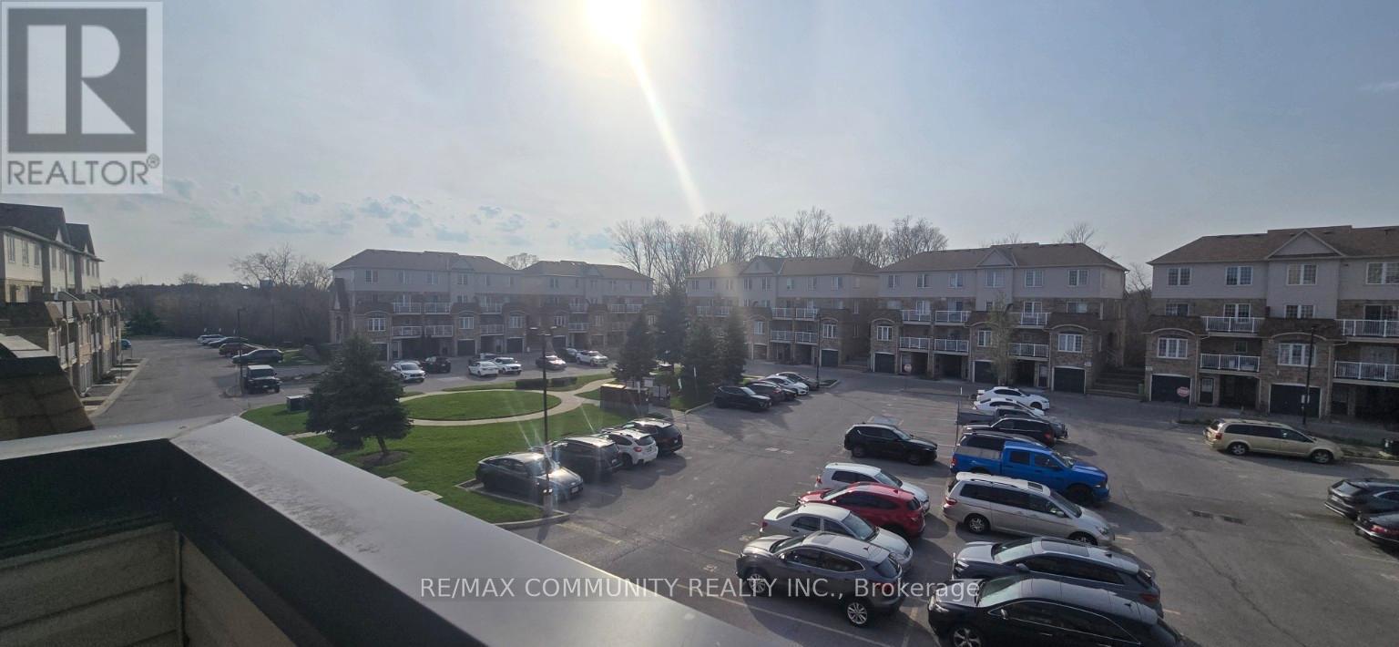 A sunny day at a parking lot with cars parked and apartment buildings in the background.