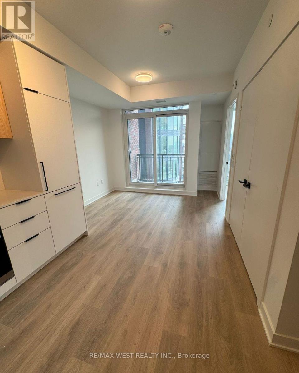 A long hallway with wood floors and white walls.