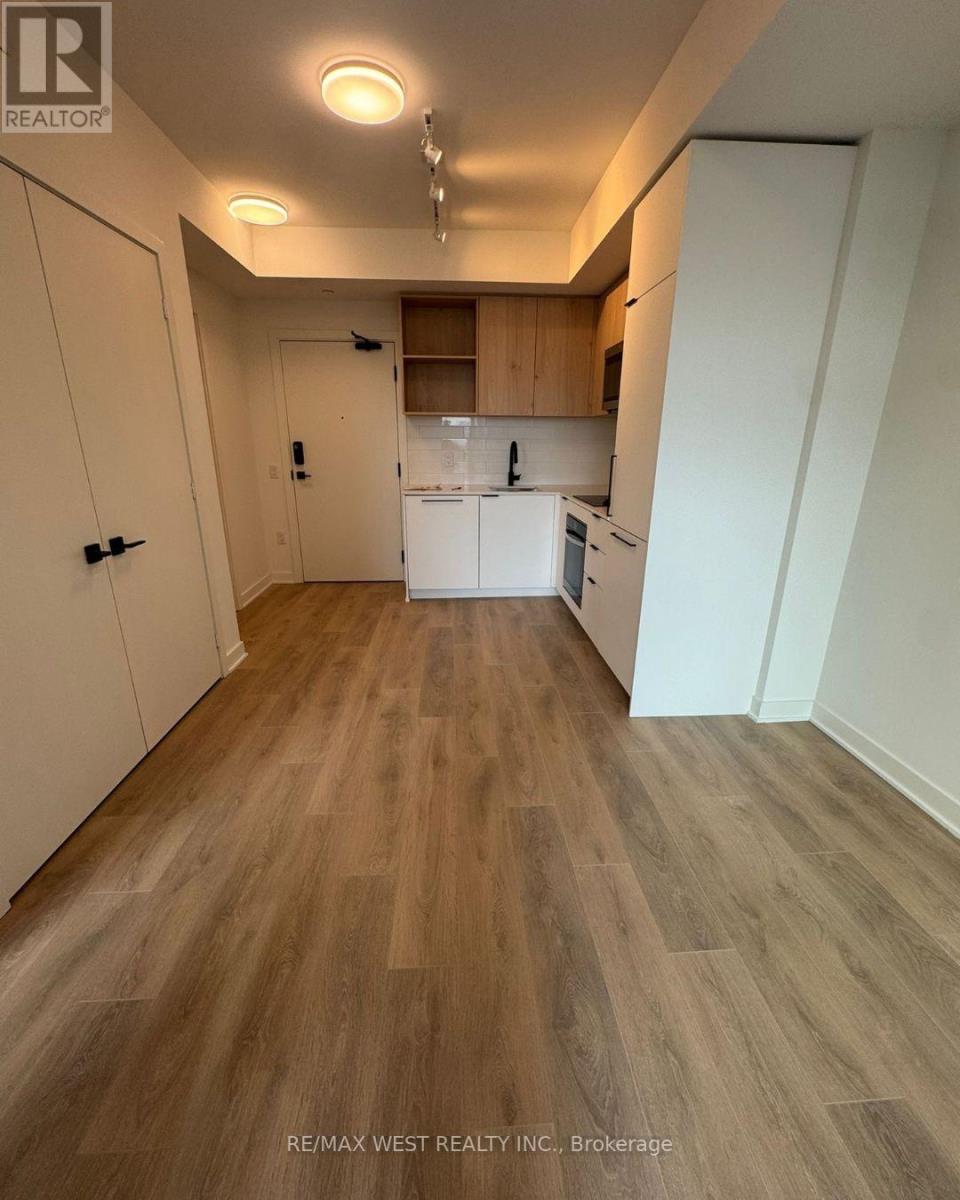 A kitchen with white appliances and wooden floors.