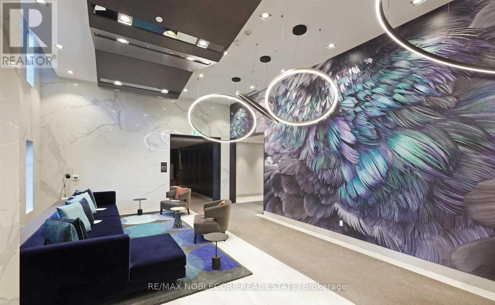 A modern living room with a large mural of a bird's feathers on the wall.