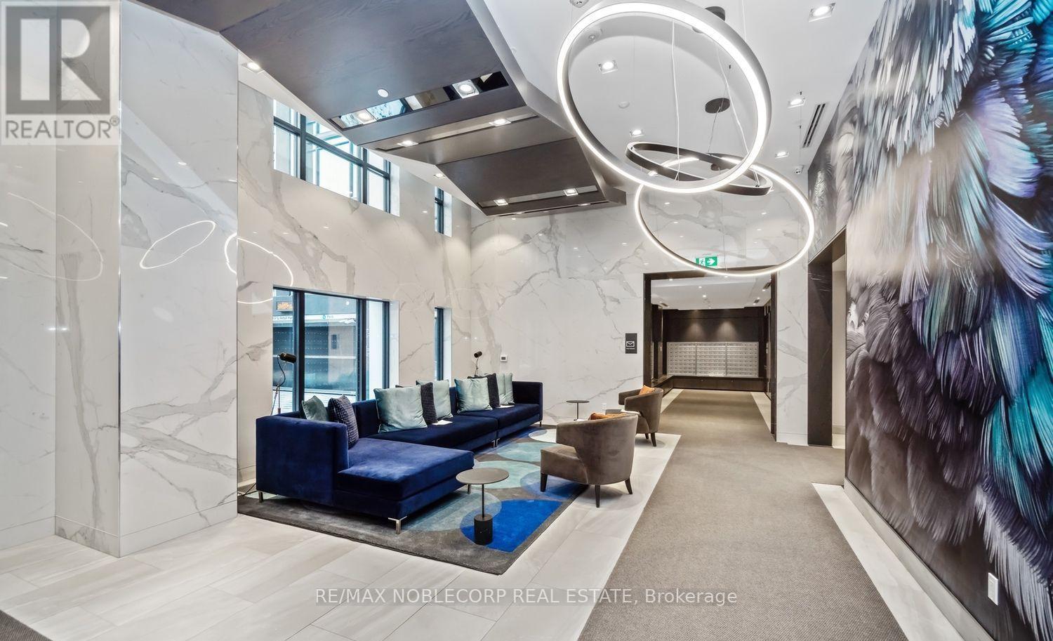 A modern office space with a blue sofa and a large mural on the wall.