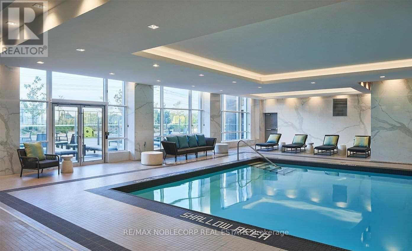 A large indoor swimming pool with a marble floor and walls.