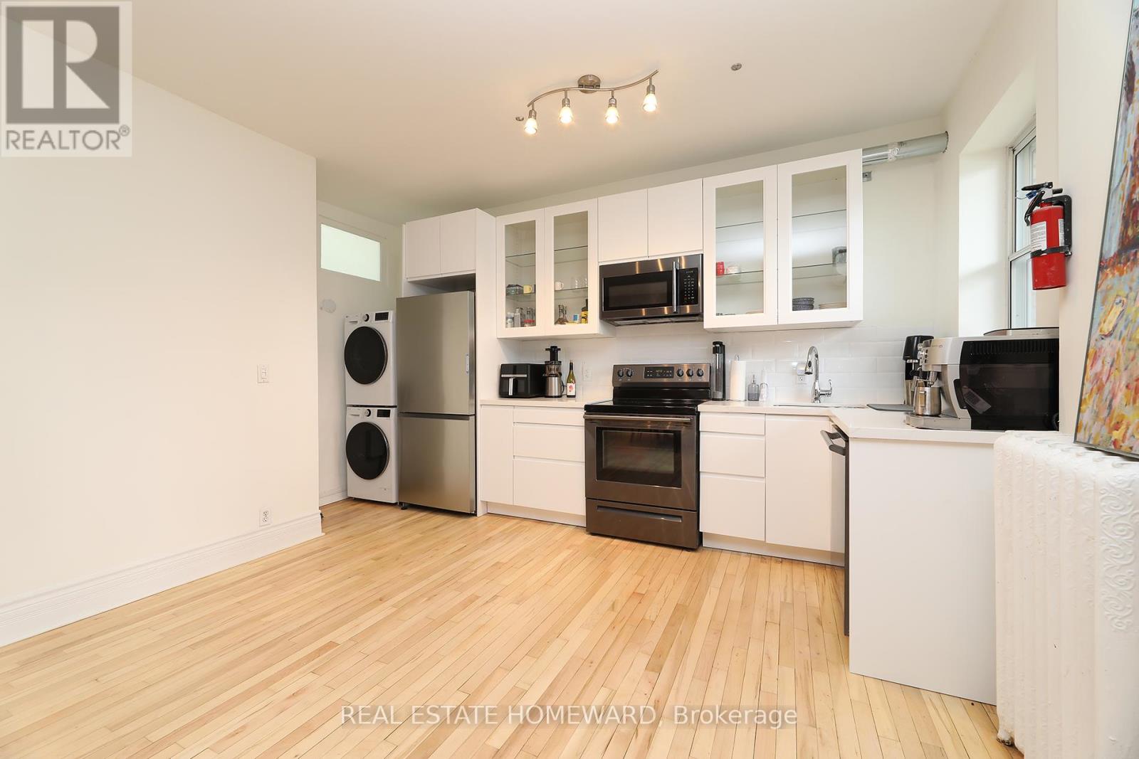 A well-lit kitchen with wooden floors and modern appliances.