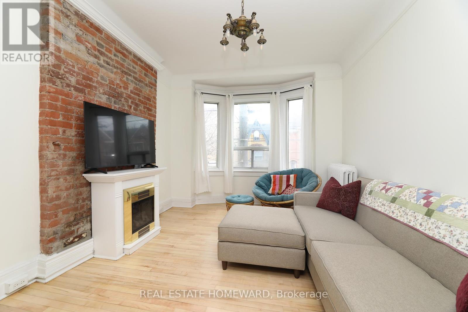 A living room with a brick fireplace and a couch.