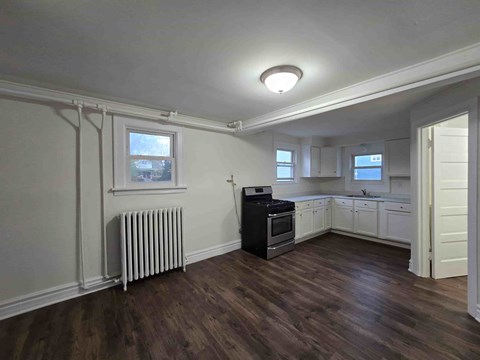 A kitchen with a black stove top oven and white cabinets.