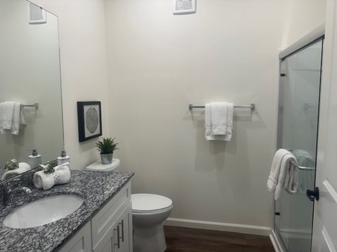 A bathroom with a toilet, sink, and towel rack.