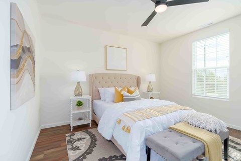 A bedroom with a large bed and a ceiling fan.