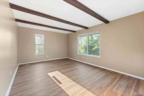 A room with wooden flooring and a large window.