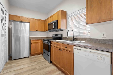 A kitchen with wooden cabinets and a stainless steel refrigerator.