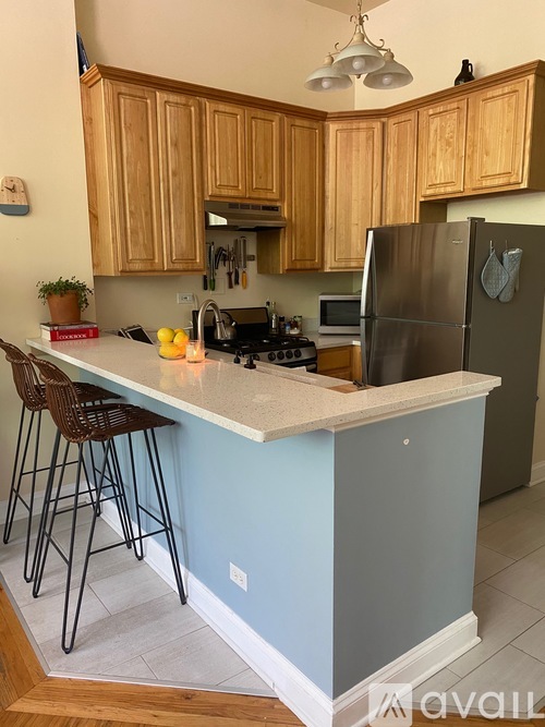 A kitchen with wooden cabinets and a blue island.