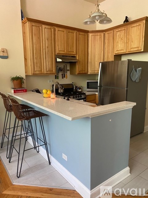 A kitchen with wooden cabinets and a blue island.