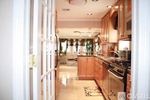 A kitchen with wooden cabinets and a stove top oven.