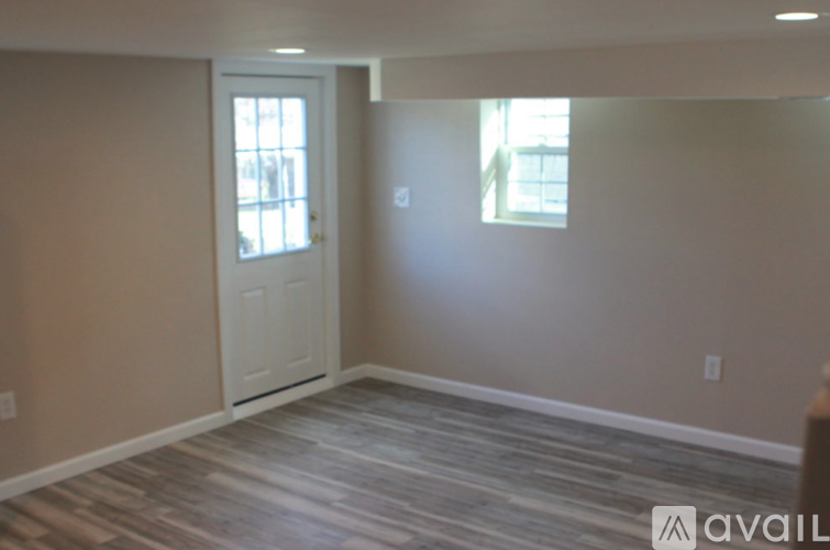 A room with a wooden floor and a white door.