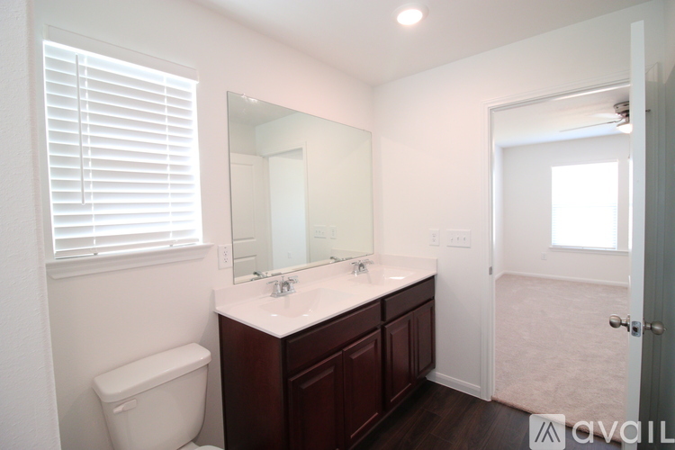 A bathroom with a toilet, sink, and mirror.