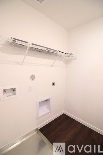 A white wall with a shelf and a small hole in the wall.