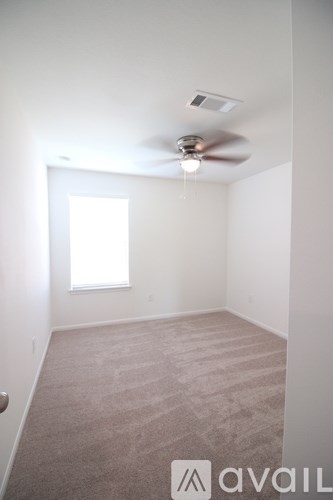 A room with a carpet floor and a ceiling fan.