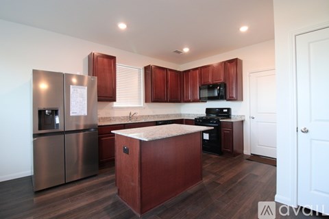 A kitchen with wooden cabinets and a stainless steel refrigerator.