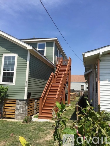 A house with a green siding and a brown staircase.