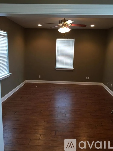 A room with a wooden floor and a ceiling fan.