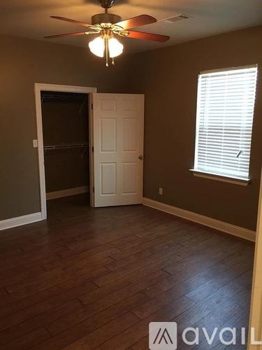 A room with a ceiling fan and a doorway leading to another room.