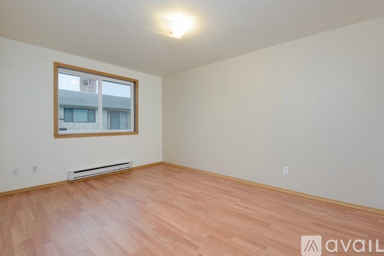A room with wooden flooring and a window.