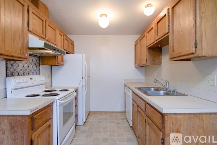 A kitchen with wooden cabinets and white appliances.
